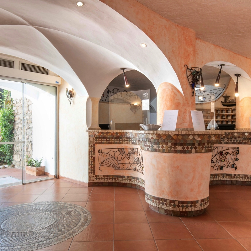 Empfangsbereich im Club Hotel Cormorano mit Rezeption und Eingangsbereich.