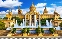 Historisches Gebäude mit Brunnen und Treppen vor blauem Himmel.