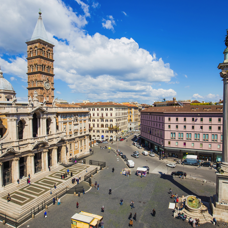 Blick auf eine belebte Piazza mit der Basilika Santa Maria Maggiore und einer Säule in Rom.