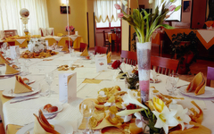 Festlicher Tisch in einem Restaurant mit Blumen und gedecktem Geschirr.