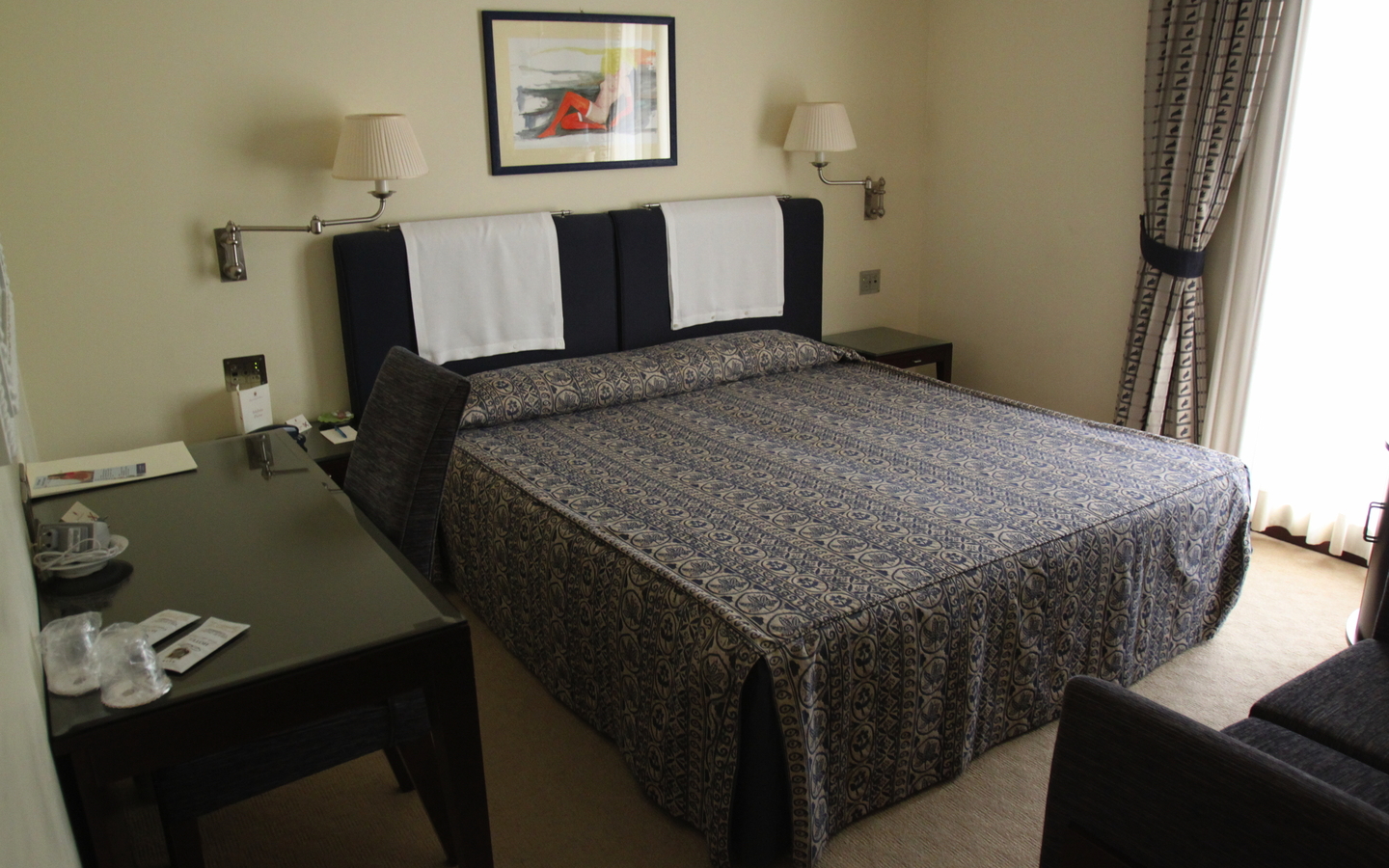 Doppelzimmer in einem Hotel mit einem Bett, Schreibtisch und Stühlen.