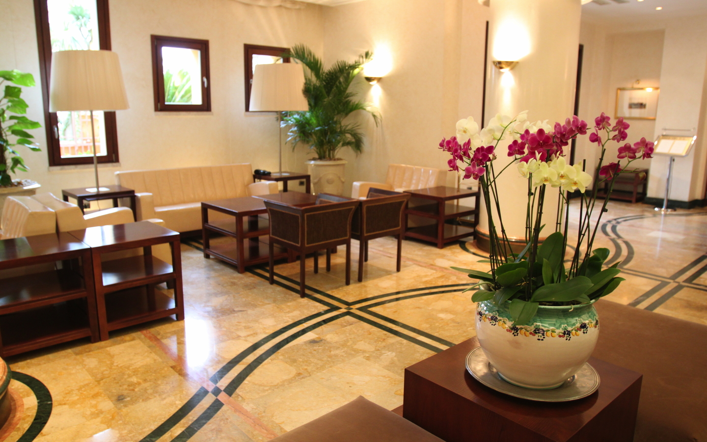 Helle Lounge mit Pflanzen und Sitzgelegenheiten im Hotel Cala del Porto in Kalabrien.