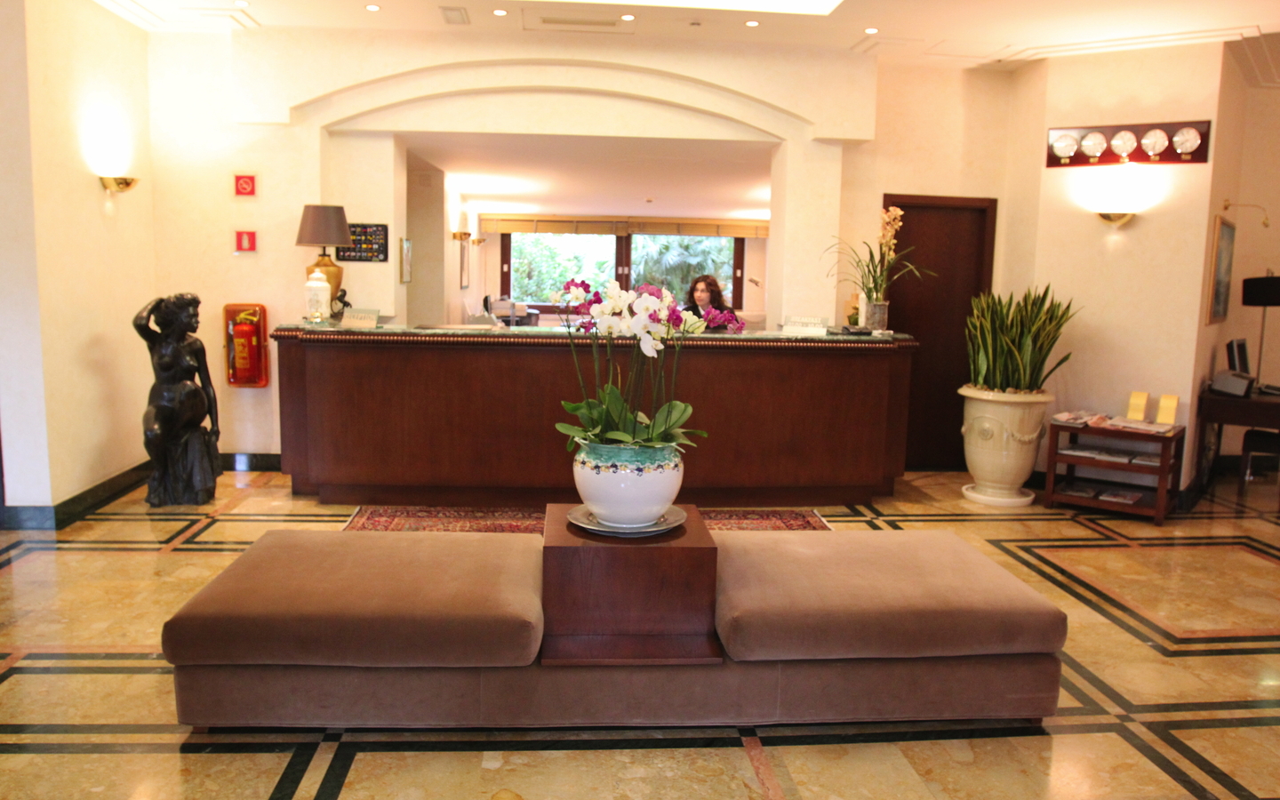 Rezeption eines Hotels mit Sitzbereich und Pflanzen.