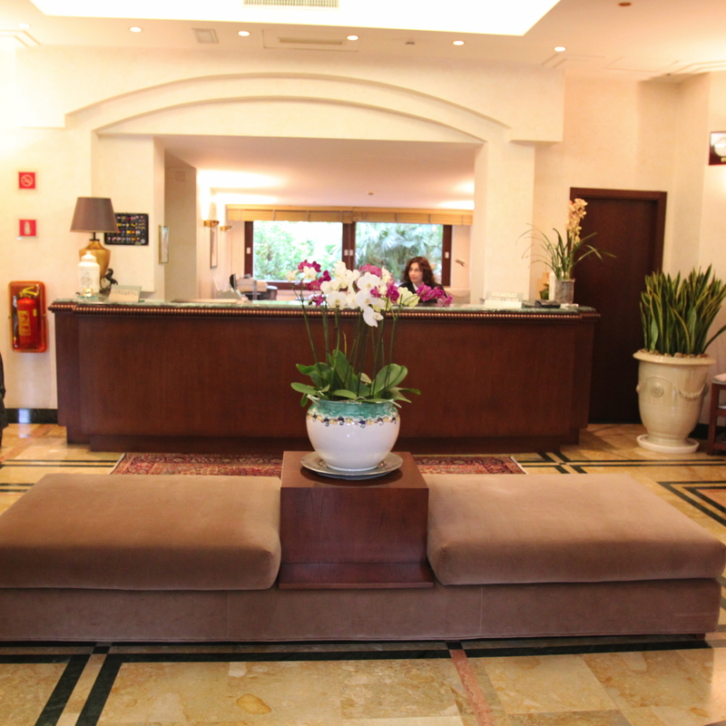 Rezeption eines Hotels mit Sitzbereich und Pflanzen.