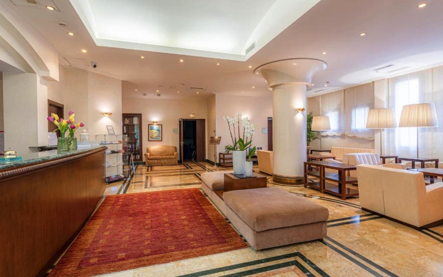 Helle Hotel-Lobby mit bequemen Sitzgelegenheiten und Pflanzen.