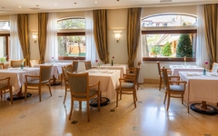 Helles Restaurant mit gedeckten Tischen und großen Fenstern im Hotel Cala del Porto.