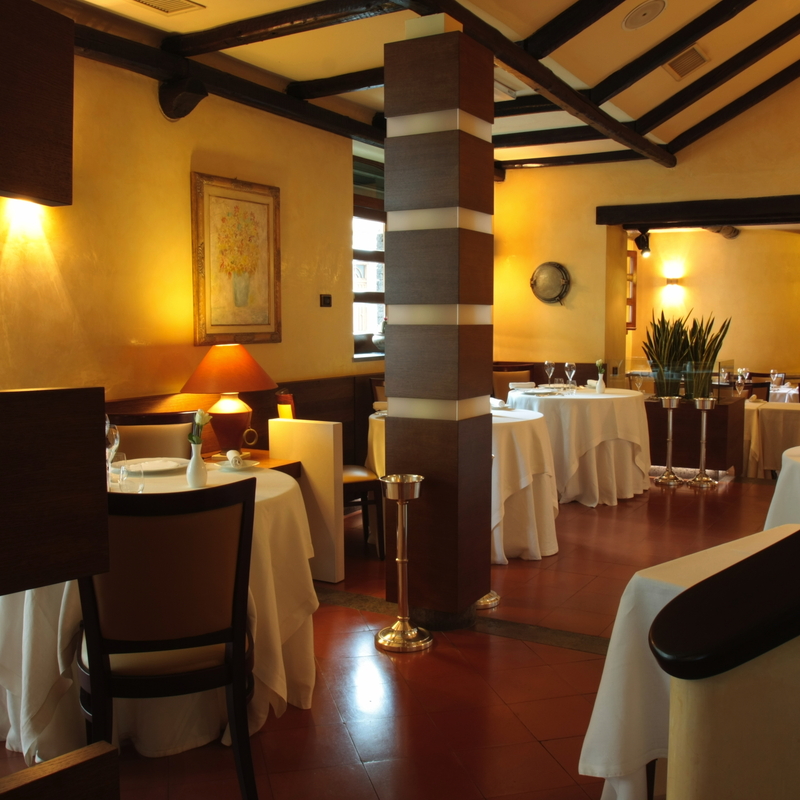 Elegant eingerichtetes Restaurant mit gedeckten Tischen und stilvoller Beleuchtung.