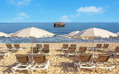 Strand mit Liegestühlen und Sonnenschirmen, Blick auf das Meer in Kalabrien, Italien.
