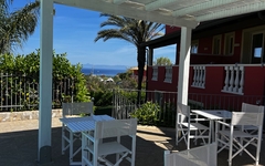 Gartenbereich mit weißen Möbeln und Meerblick im Hotel Borgo di Santa Barbara, Kalabrien.