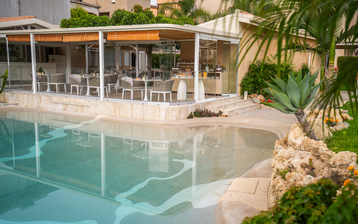 Außenansicht eines Hotels mit modernen Verandamöbeln und Swimmingpool.