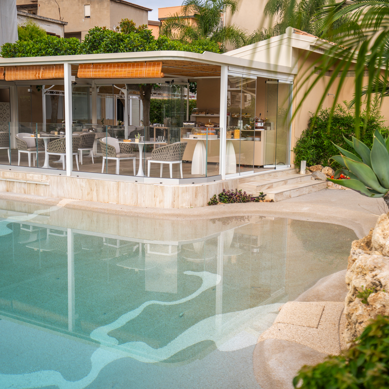 Außenansicht eines Hotels mit modernen Verandamöbeln und Swimmingpool.