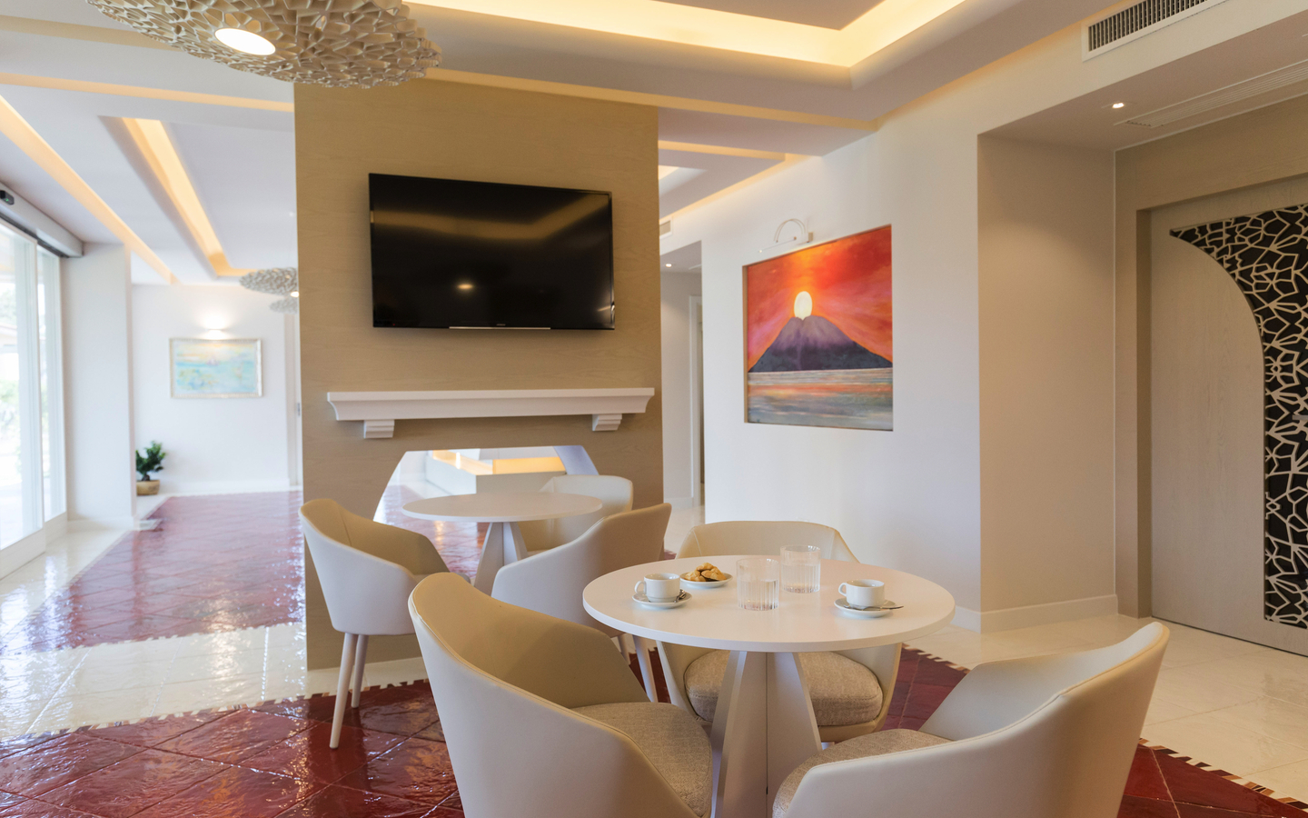 Moderne Hotelsuite mit Tisch, Stühlen und Wandkunst.