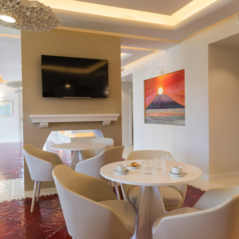 Moderne Hotelsuite mit Tisch, Stühlen und Wandkunst.