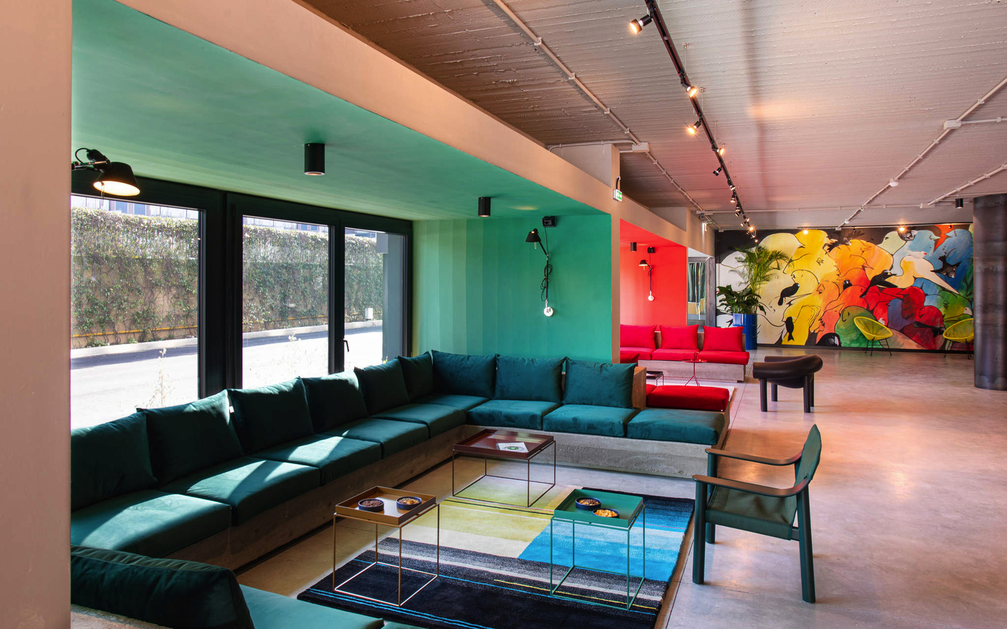 Moderne Hotellounge mit bunten Wandmalereien und stilvollen Möbeln.