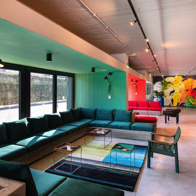 Moderne Hotellounge mit bunten Wandmalereien und stilvollen Möbeln.