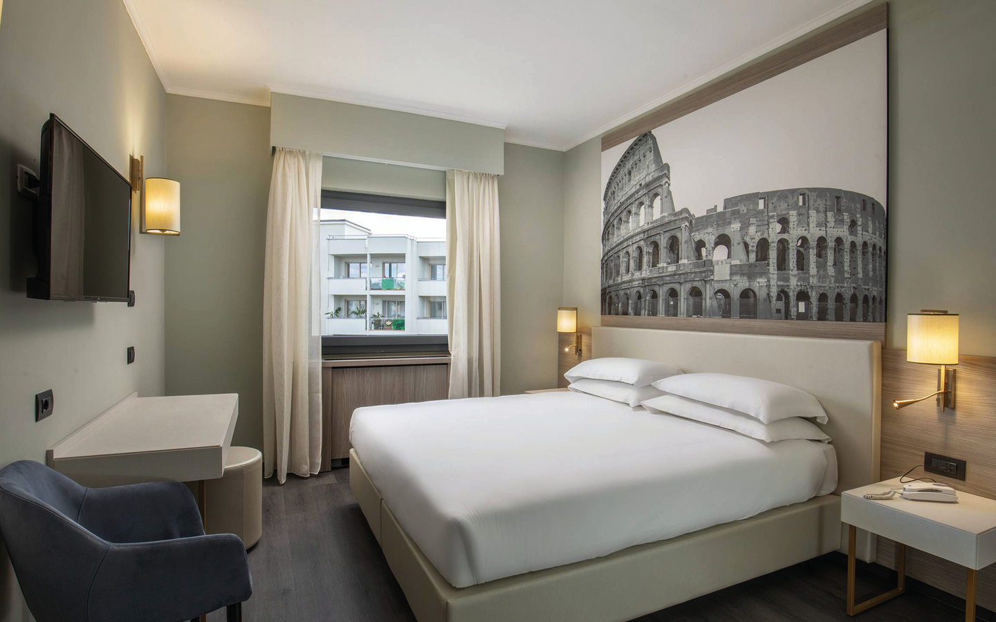 Modernes Hotelzimmer mit Doppelbett und großem Wandbild des Kolosseums.