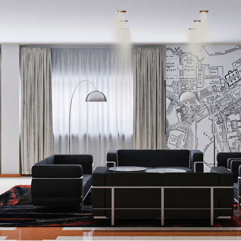 Lounge eines Hotels in Rom mit schwarzen Sofas und Stadtplan an der Wand.