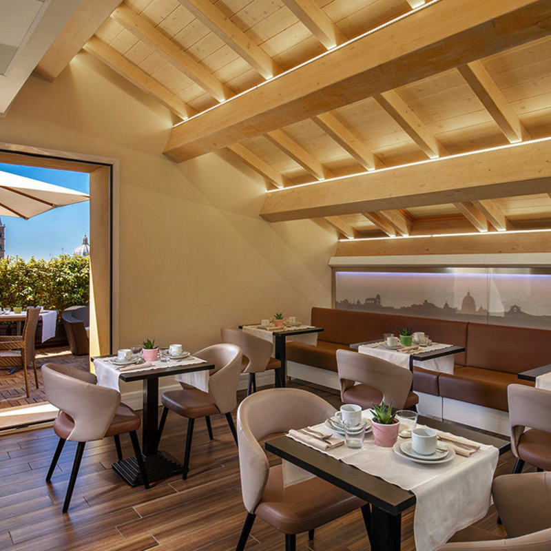 Frühstücksraum mit gedeckten Tischen und Blick auf Terrasse im Hotel Gioberti, Rom.