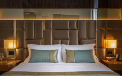 Hotelzimmer mit Doppelbett, dekorativen Kissen und eleganter Beleuchtung.