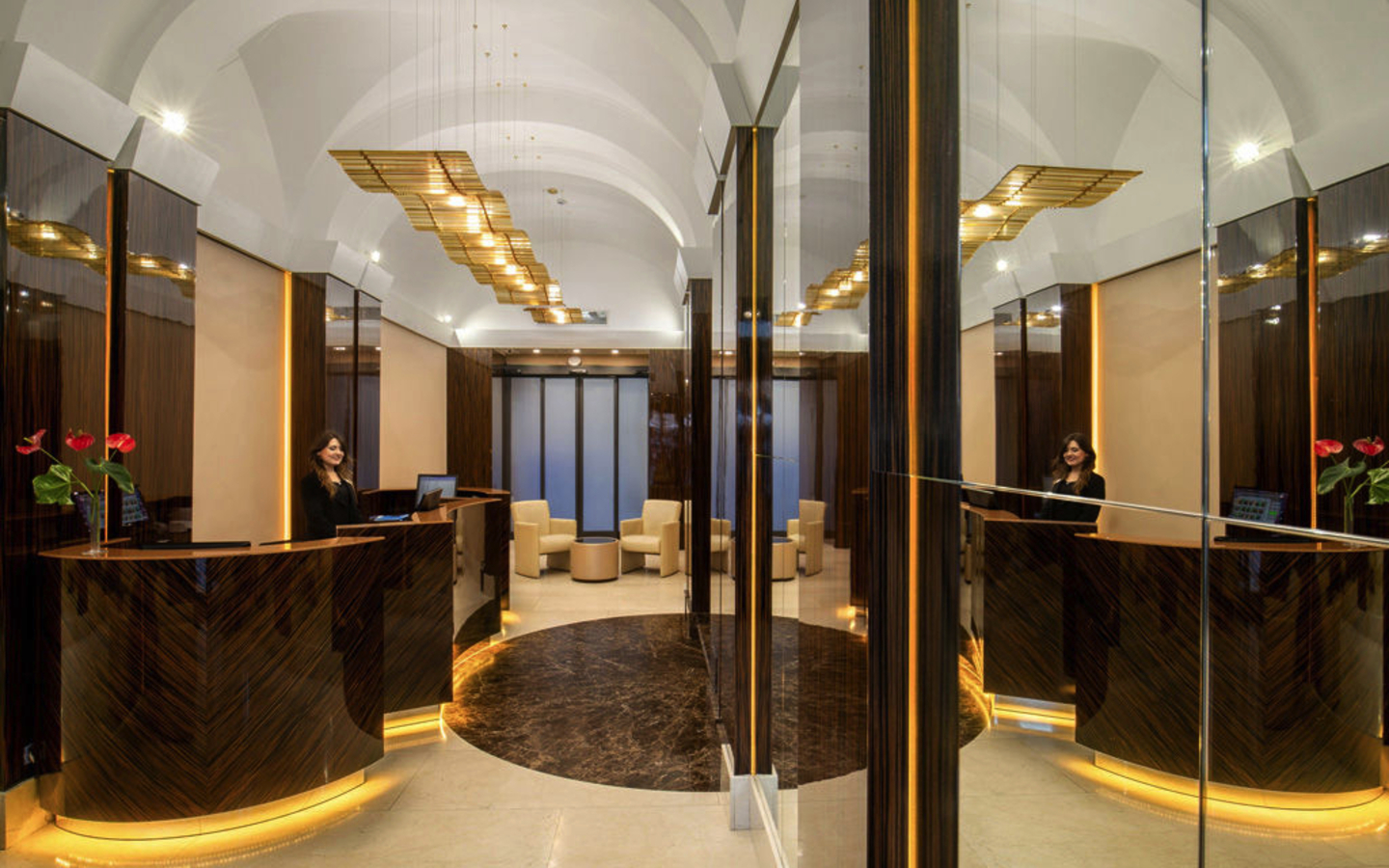 Lobby des Hotel Gioberti in Rom mit eleganter Einrichtung und Empfangstresen.