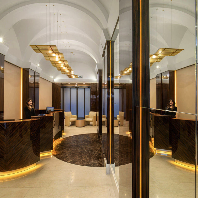 Lobby des Hotel Gioberti in Rom mit eleganter Einrichtung und Empfangstresen.