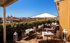 Terrasse des Hotel Gioberti in Rom mit Tischen und Sonnenschirmen, Blick auf die Stadt.