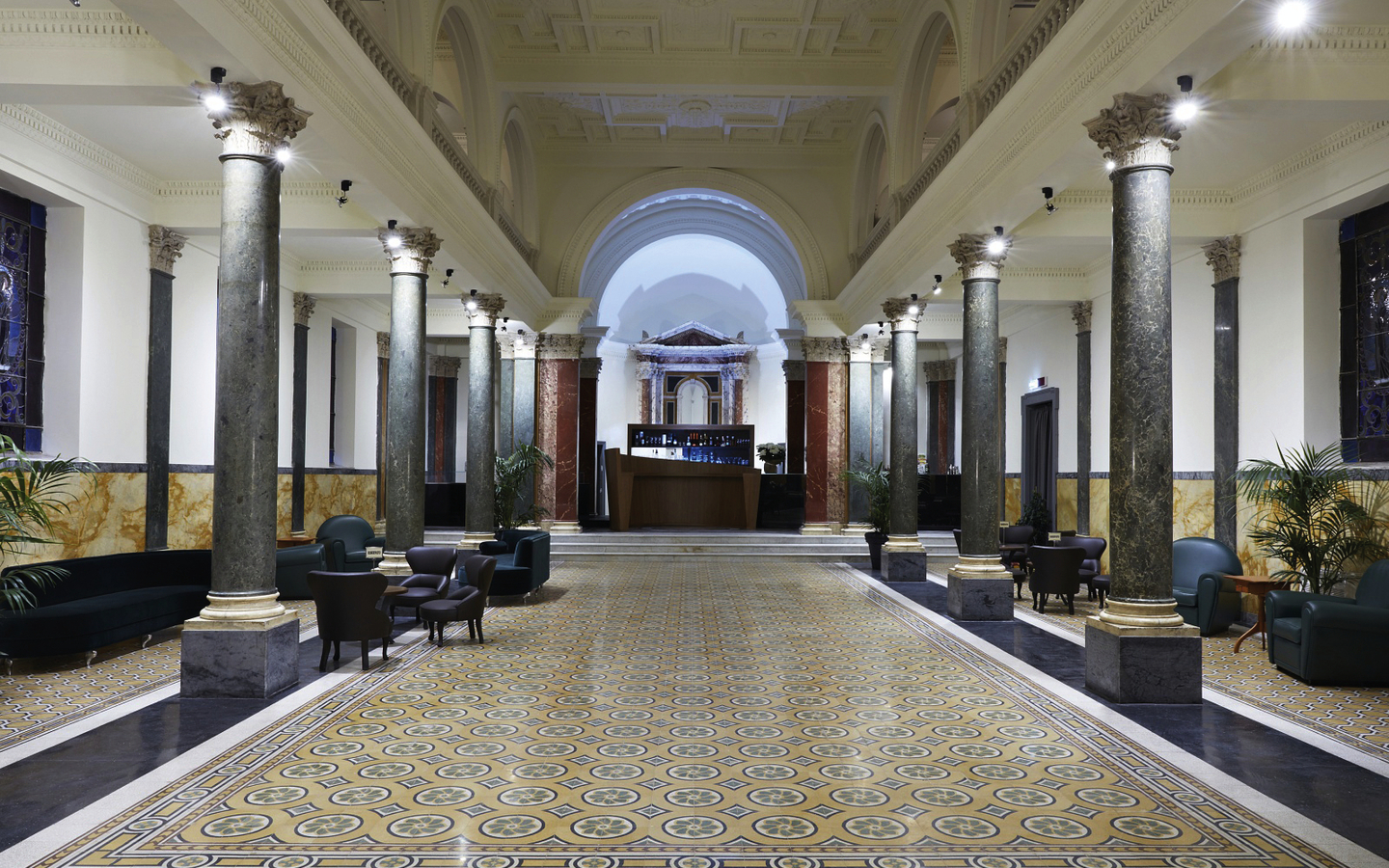 Große, elegante Hotellobby mit Marmorsäulen und verziertem Boden in Rom.