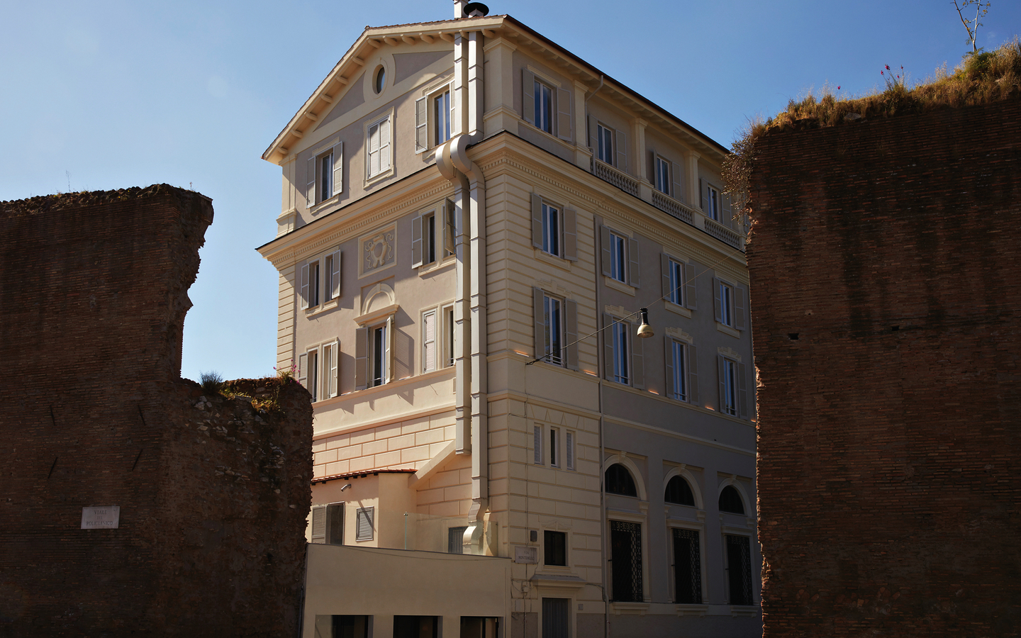 Fassade eines mehrstöckigen, weißen Gebäudes in Rom, Italien.