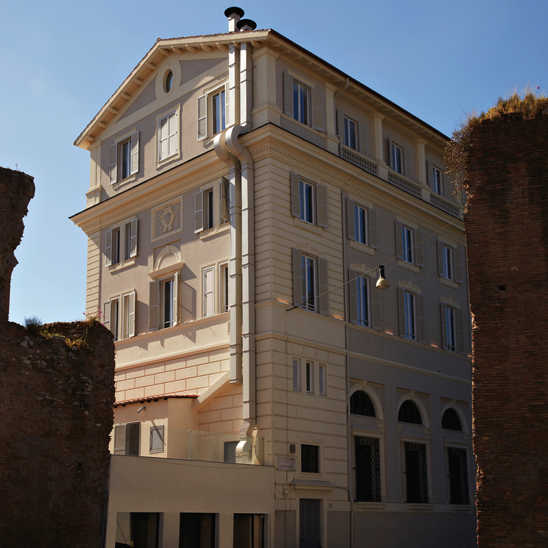 Fassade eines mehrstöckigen, weißen Gebäudes in Rom, Italien.