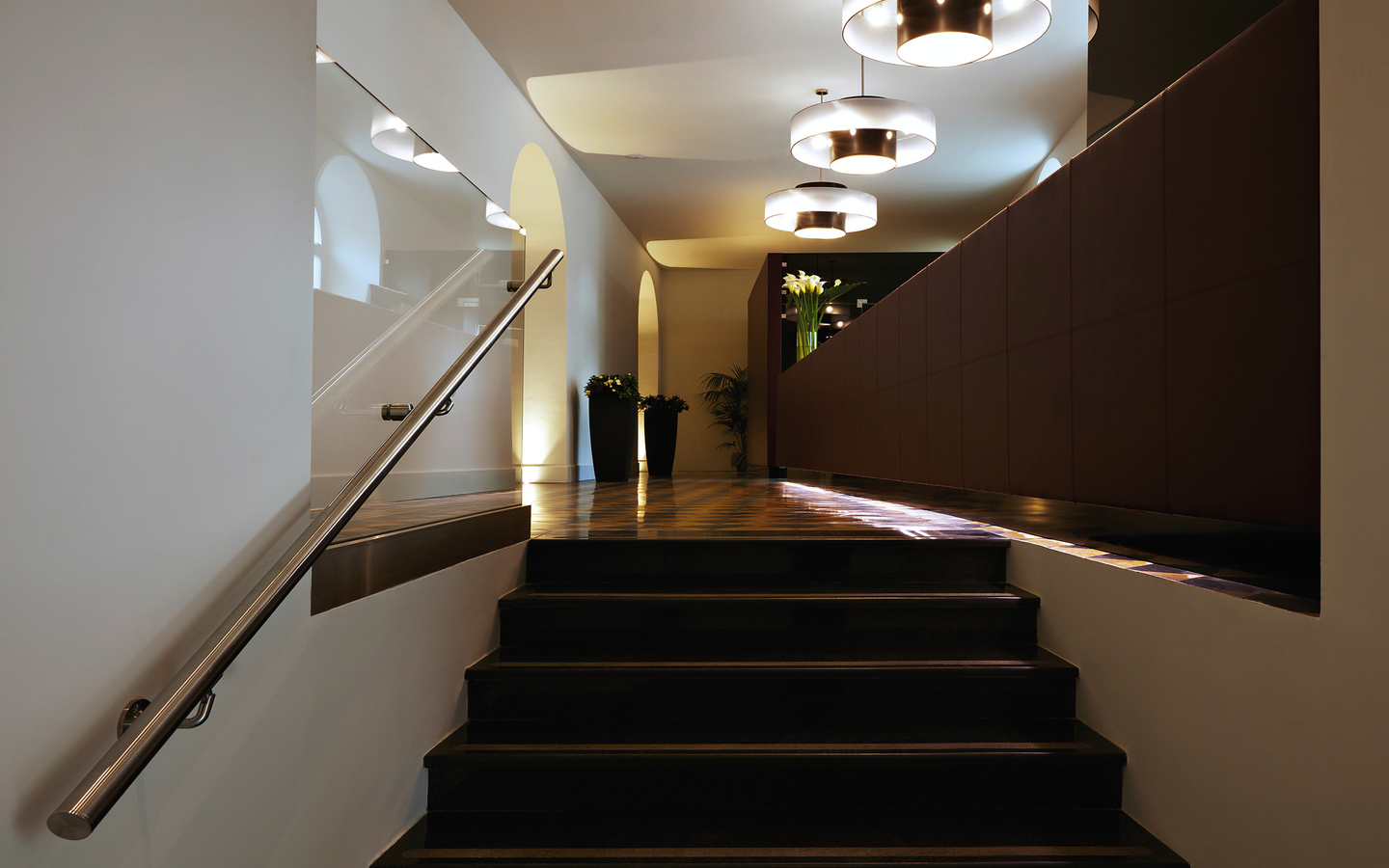 Treppe im modernen Hotel mit eleganter Beleuchtung und Pflanzenarrangement