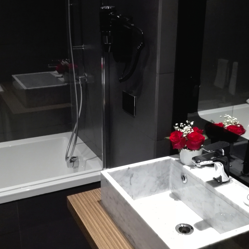 Modernes Badezimmer mit Waschbecken, Spiegel und Badewanne.
