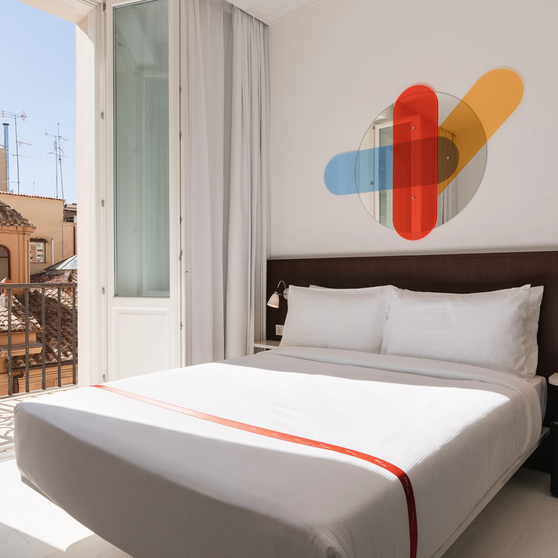 Helles Hotelzimmer mit Balkon in Rom und moderner Dekoration.