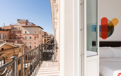 Balkon mit Blick auf römische Gebäude bei sonnigem Wetter.