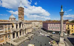 Blick auf eine belebte Piazza mit der Basilika Santa Maria Maggiore und einer Säule in Rom.