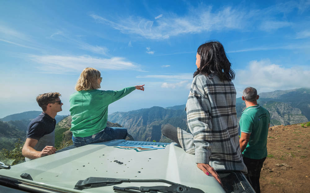 Personen auf Jeep genießen Aussicht ins Nonnental, Madeira, bei sonnigem Wetter.