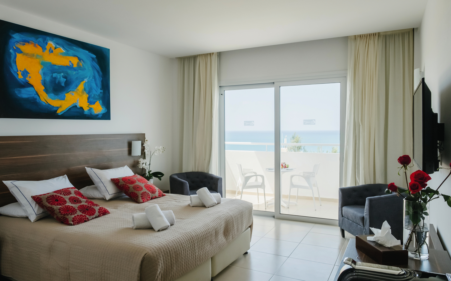 Doppelzimmer mit Teilmeerblick, modernen Möbeln und heller Dekoration.