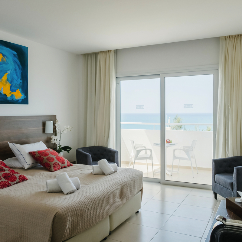 Doppelzimmer mit Teilmeerblick, modernen Möbeln und heller Dekoration.