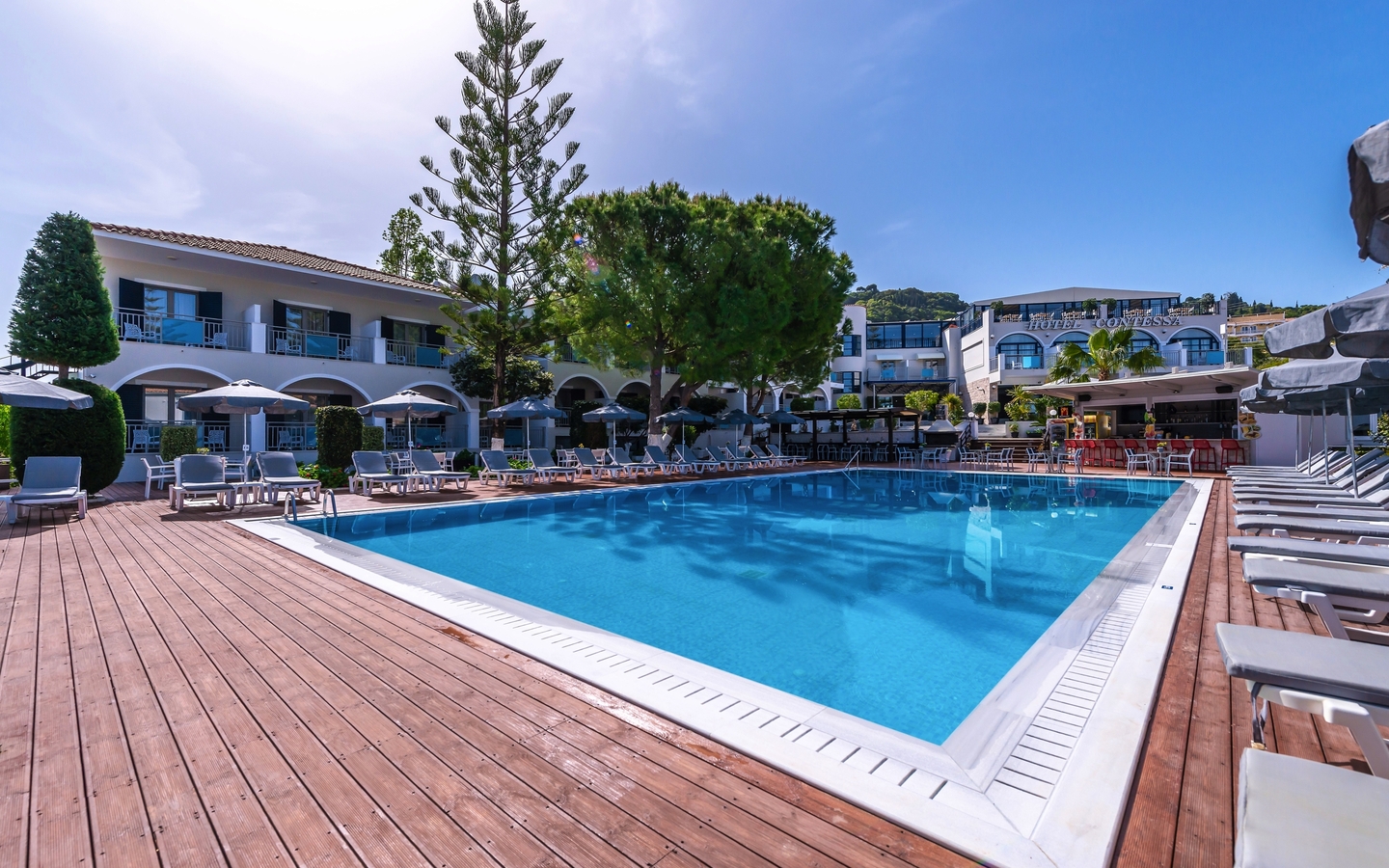 Außenansicht vom Hotel Contessa in Griechenland mit Pool und Sonnenschirmen.