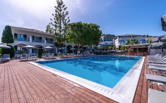 Außenansicht vom Hotel Contessa in Griechenland mit Pool und Sonnenschirmen.