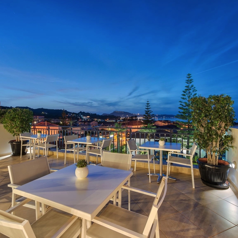 Restaurantterrasse mit Nachtblick, Tische und Stühle unter freiem Himmel in Griechenland.