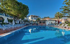 Poolbereich eines Hotels auf Zakynthos, Griechenland mit Liegestühlen und Sonnenschirmen.