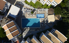 Luftaufnahme eines Hotelkomplexes mit zwei Pools und umliegenden Gebäuden.