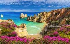 Küstenlandschaft mit Felsen, Strand und Meer bei Praia do Camilo, Algarve, Portugal
