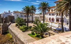 Platz mit Palmen und historischen Gebäuden in Tarifa, Spanien bei sonnigem Wetter.