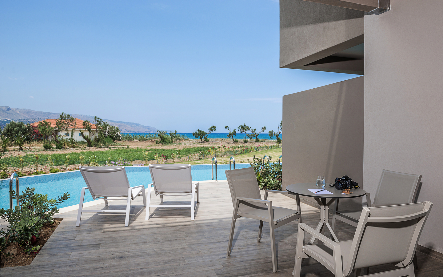 Terrasse mit Stühlen und Meerblick in einem Hotelzimmer auf Kreta.