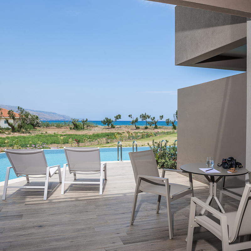 Terrasse mit Stühlen und Meerblick in einem Hotelzimmer auf Kreta.