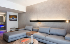 Wohnbereich einer Familiensuite mit grauem Sofa und modernem Design.