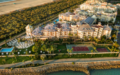 Luftaufnahme eines Hotels mit Pool und Tennisplatz am Strand von Isla Canela, Spanien.