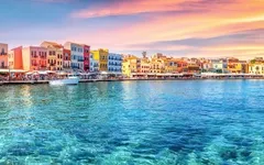 Traditioneller Hafen von Chania, Kreta bei Sonnenuntergang mit bunten Gebäuden.