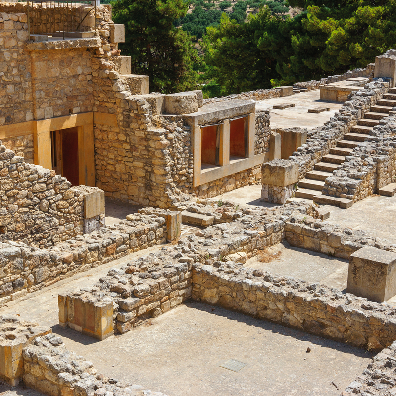 Ruinen des Palasts von Knossos auf Kreta, mit alten Steinmauern und Treppen.